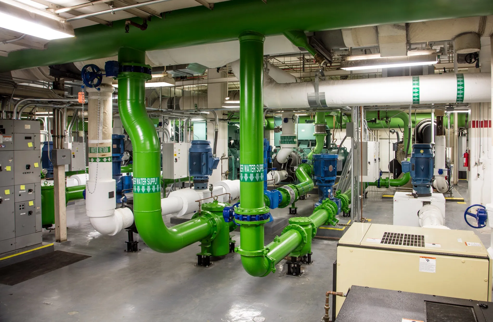 Mechanical room with HVAC piping, pumps, and equipment coordinated through building automation